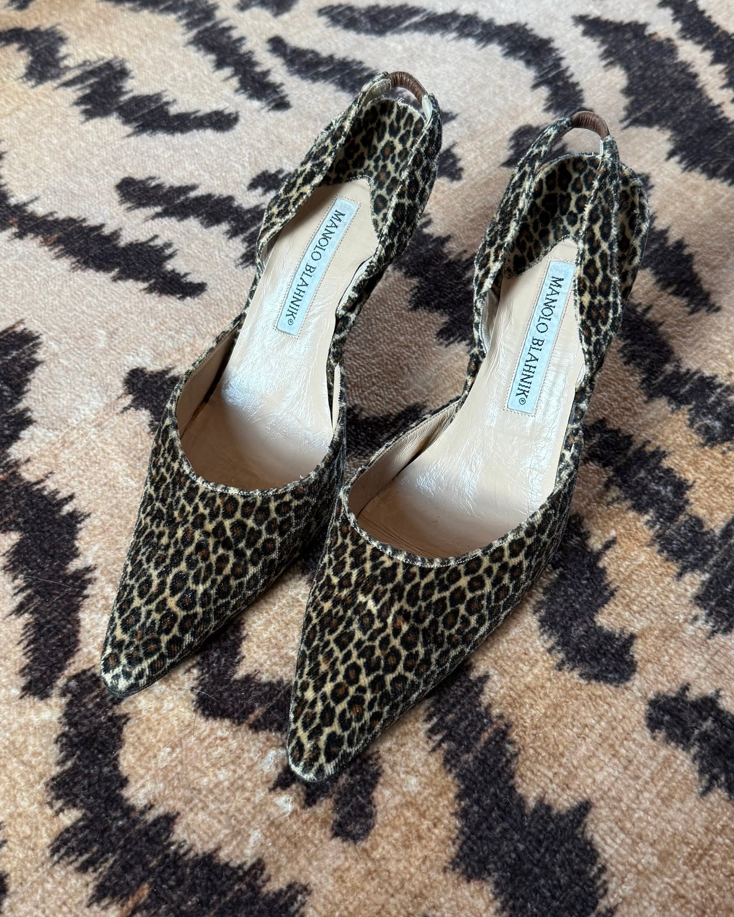 Pair of leopard print shoes on a tiger print rug surface